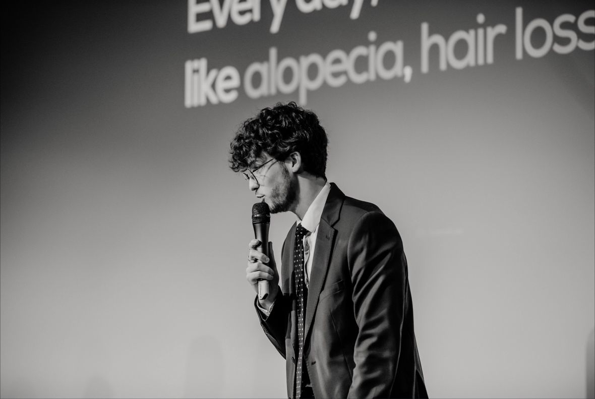 Louis-Gabin speaking into a microphone during the pitch